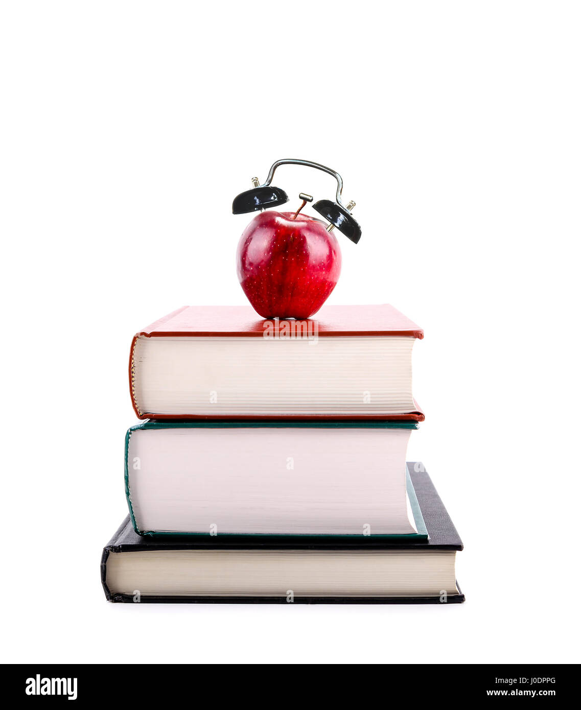 Une pomme rouge avec alarme sur une pile de livres isolé sur fond blanc. Le temps de retourner à l'école, conception de l'apprentissage, l'enseignement, l'alphabétisation. Banque D'Images