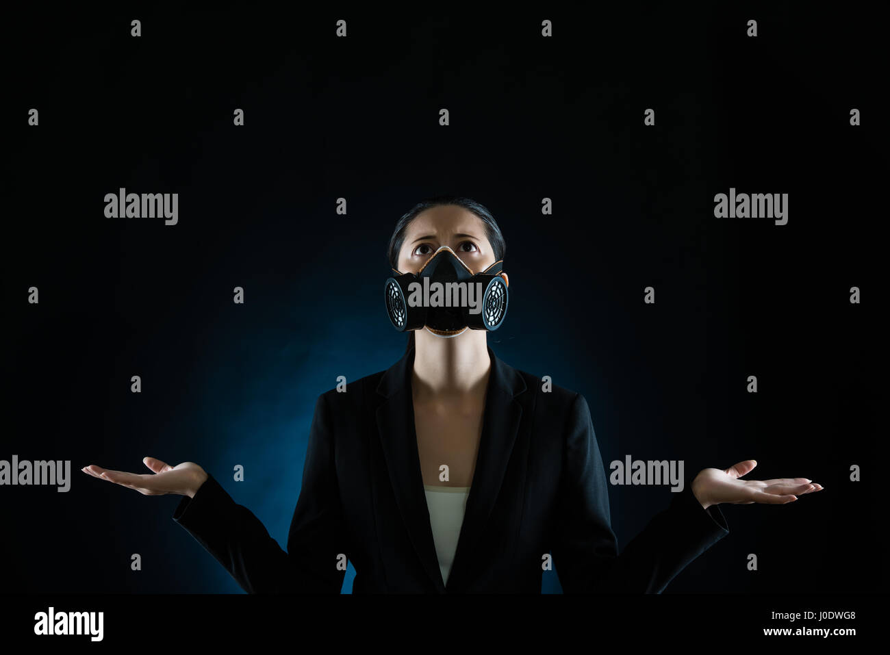 Femme d'affaires portant un masque de prier pour l'environnement pollution devenu clair sur fond noir concept. race mixte modèle chinois asiatique Banque D'Images