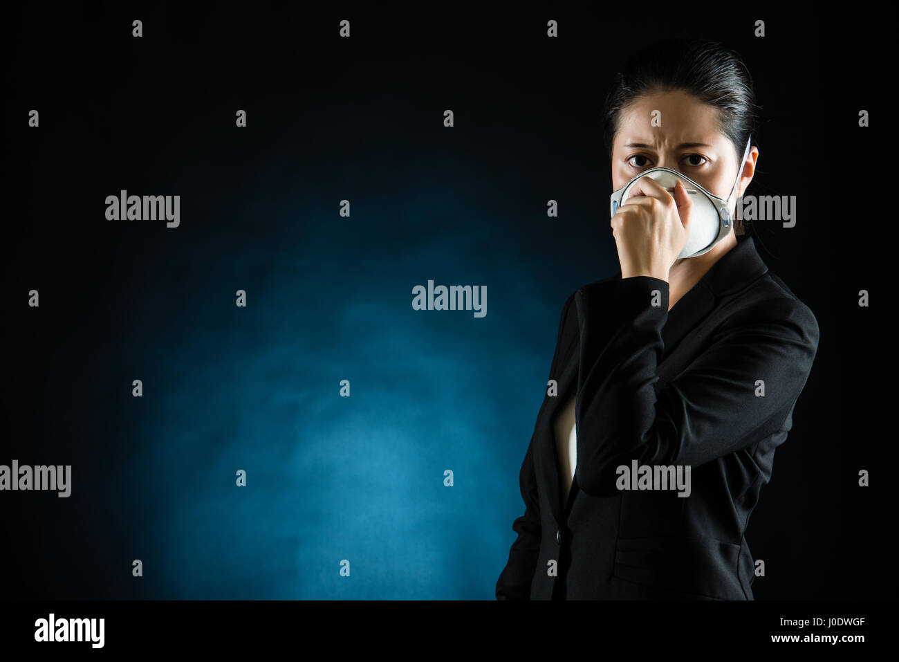 Portrait de jeune femme d'affaires portant un masque sur fond noir concept de la pollution. race mixte modèle chinois asiatique Banque D'Images