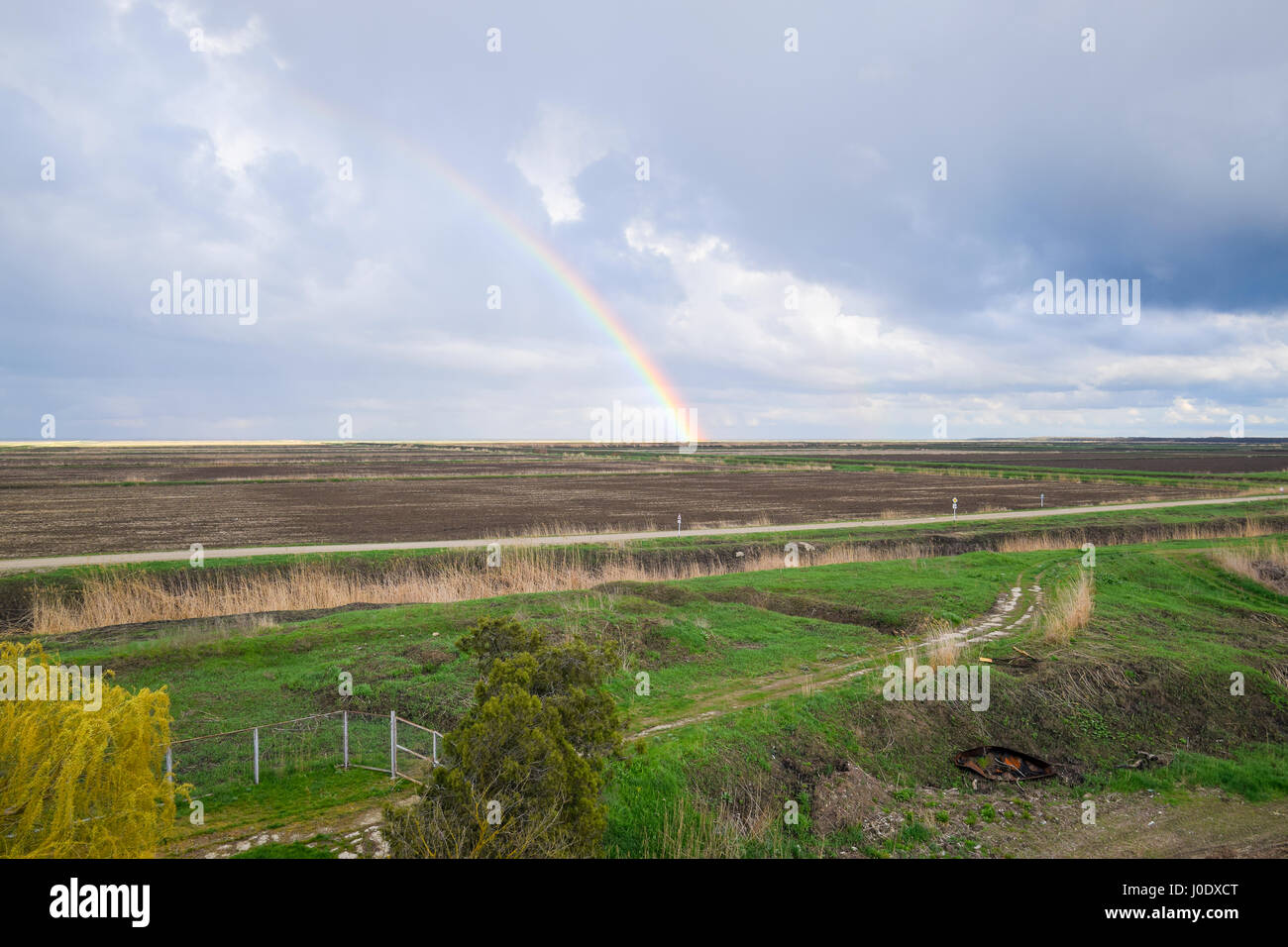 Arc-en-ciel, une vue sur le paysage dans le domaine. Formation de l'arc en ciel après la pluie. La réfraction de la lumière et de l'expansion en termes de spectres. Banque D'Images
