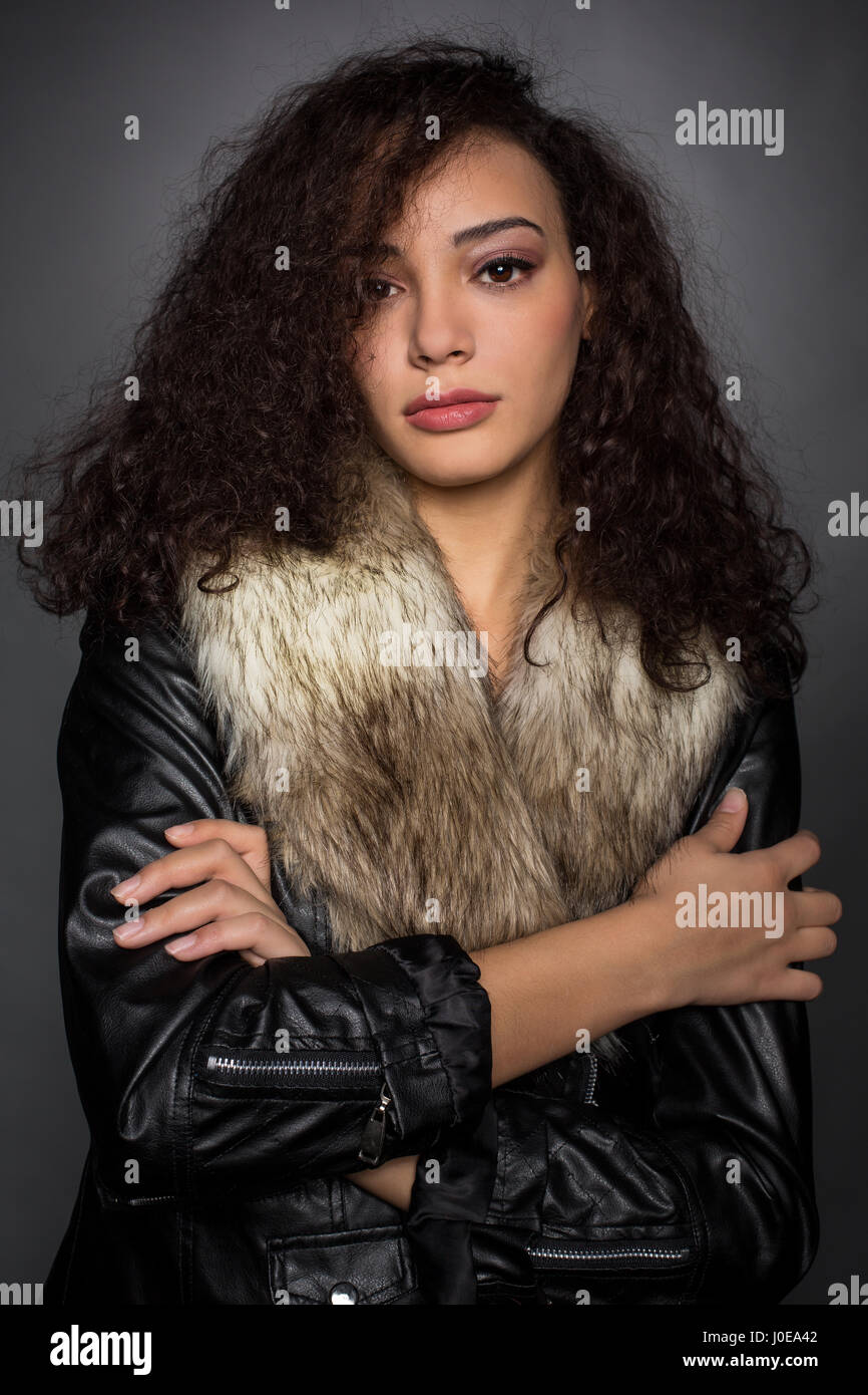 Jeune femme avec des cheveux bouclés en blouson noir, portrait, Mode, mode de vie Banque D'Images