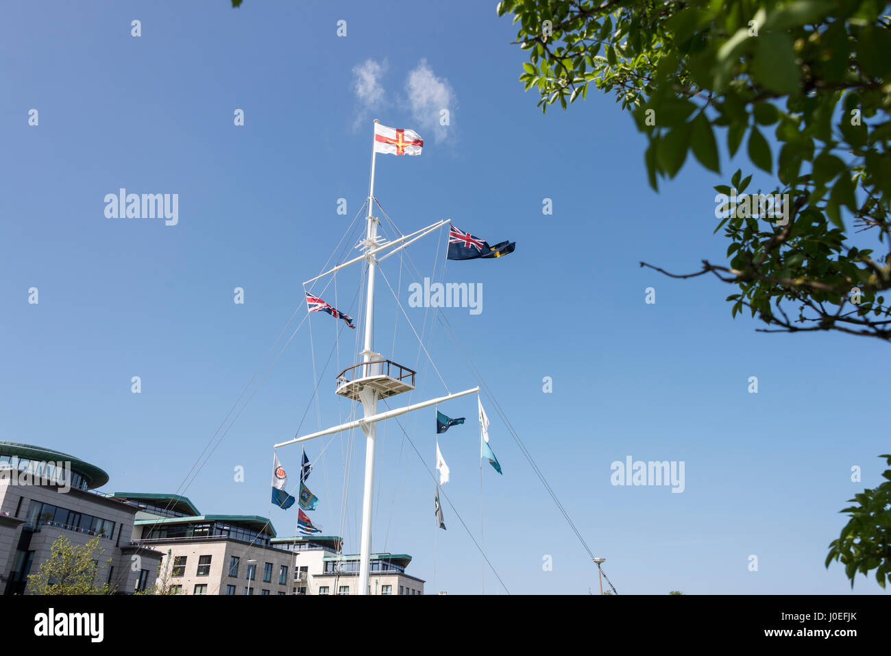 Un grand mât avec les drapeaux sur le pont-bascule rond-point dans le centre de St Peter Port dans les îles de la Manche, la Grande-Bretagne. Banque D'Images