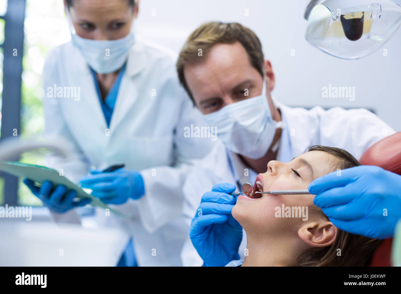 Dentiste de l'examen d'un jeune patient avec des outils dans une clinique dentaire Banque D'Images