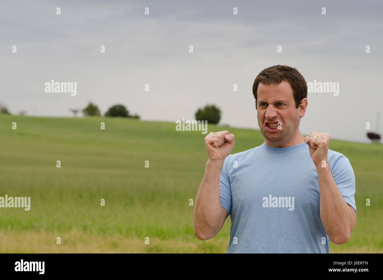 L'homme furieux avec ses poings fermés à l'extérieur à la campagne. Banque D'Images