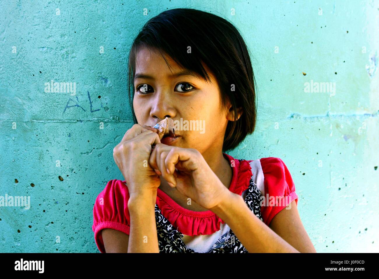 MARIKINA CITY, PHILIPPINES - le 12 février 2016 : Une jeune fille mange un bonbon Banque D'Images