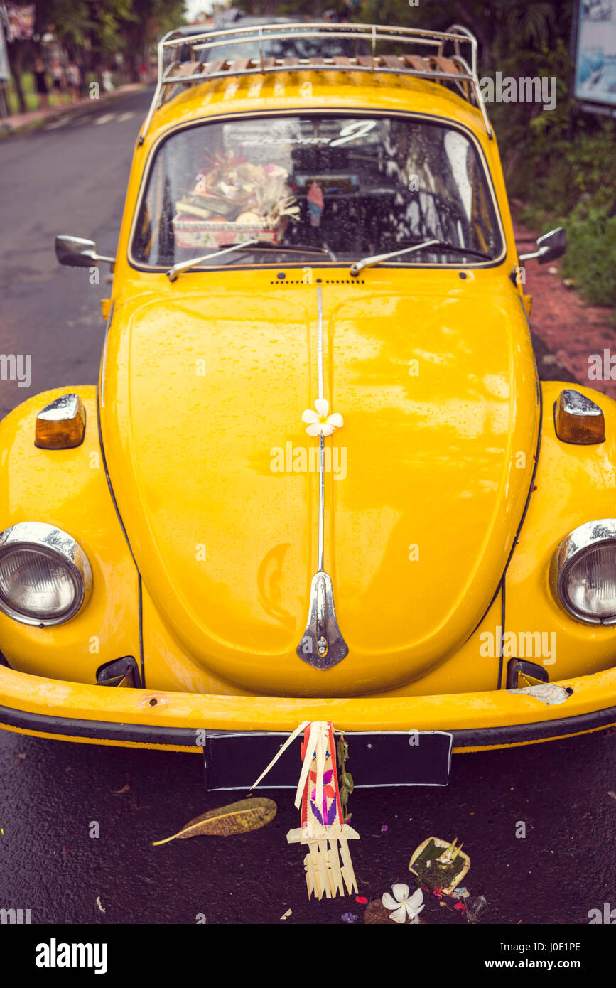 Le Pouvoir des Fleurs - fleur sur un capot d'un hippie 70s vintage jaune voiture. Retro style hippie ou beetle bug voiture restaurée. Banque D'Images