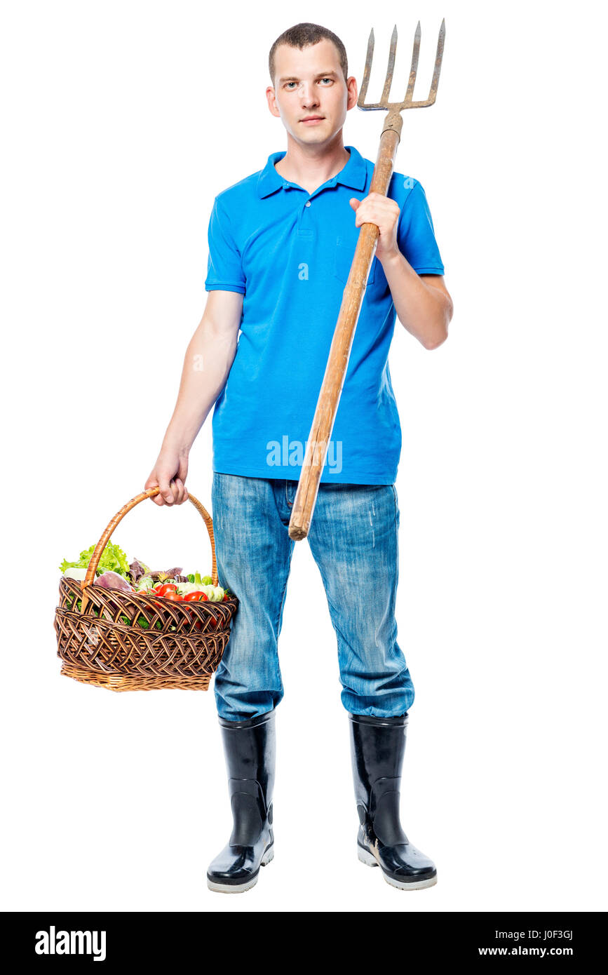 Portrait d'un agriculteur avec une fourche et un panier de légumes frais isolé Banque D'Images