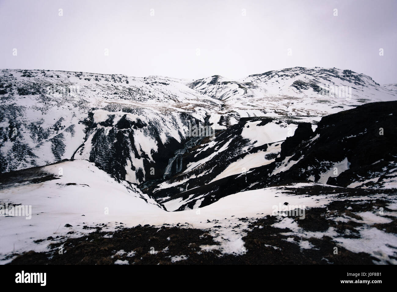 Une chute dans les montagnes près de l'eau chaude géothermique de Reykjadalur, de sentier de randonnée populaire près de Reykjavik, Islande Banque D'Images