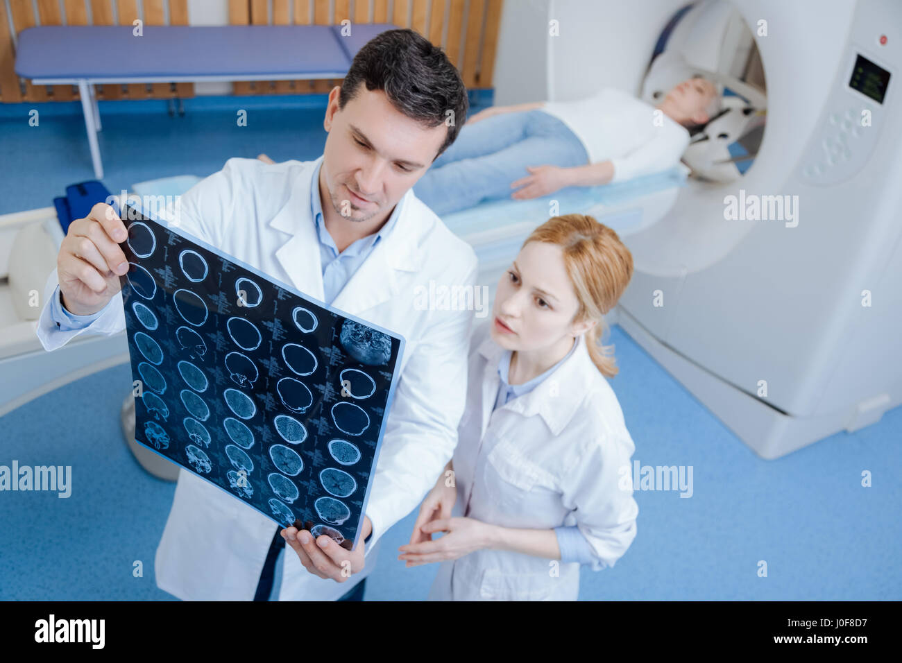 Professionnel sérieux médecin examinant les CT scans du cerveau Banque D'Images