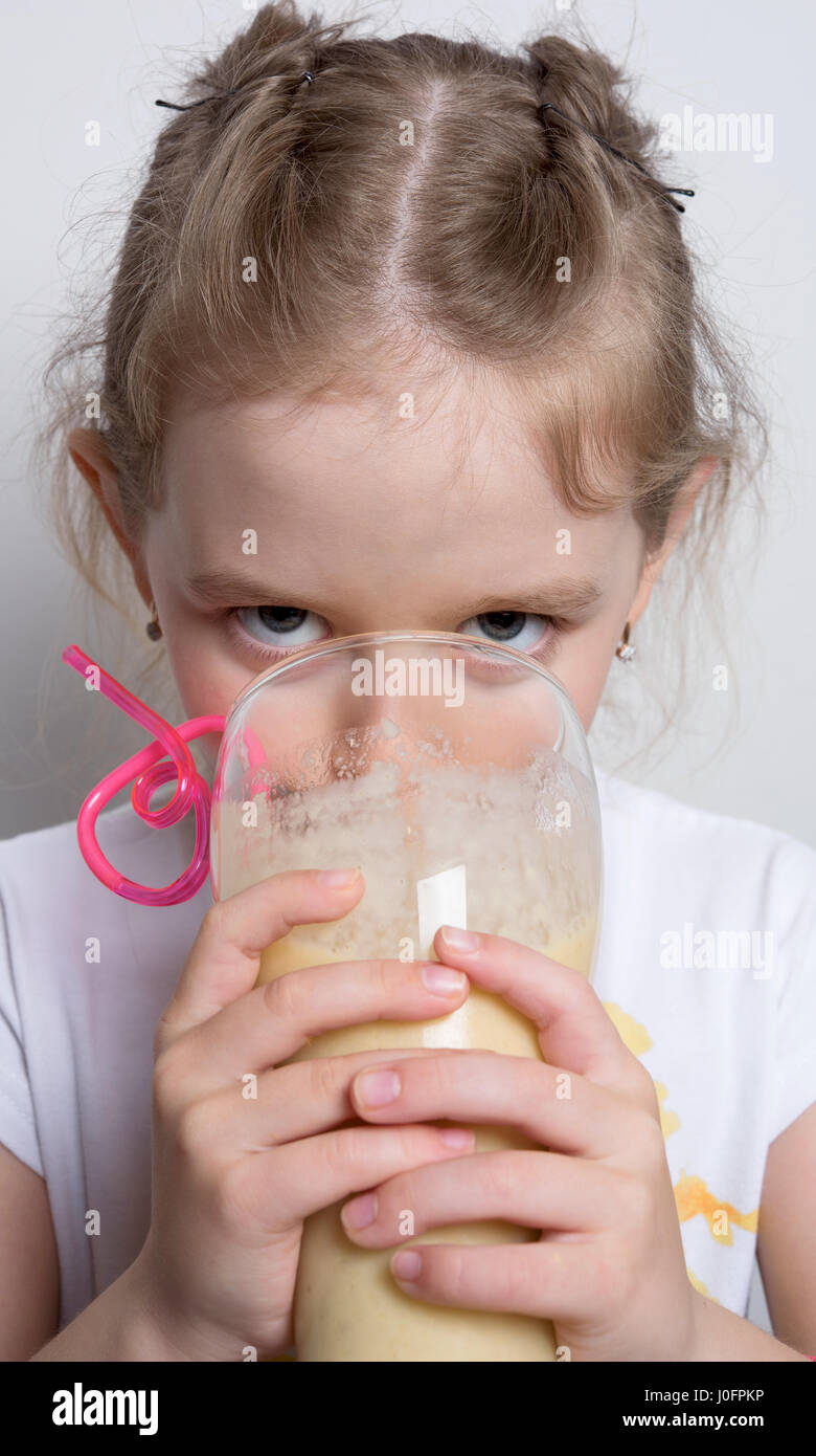 Des boissons à partir de la fille d'un grand verre de milkshake Banque D'Images
