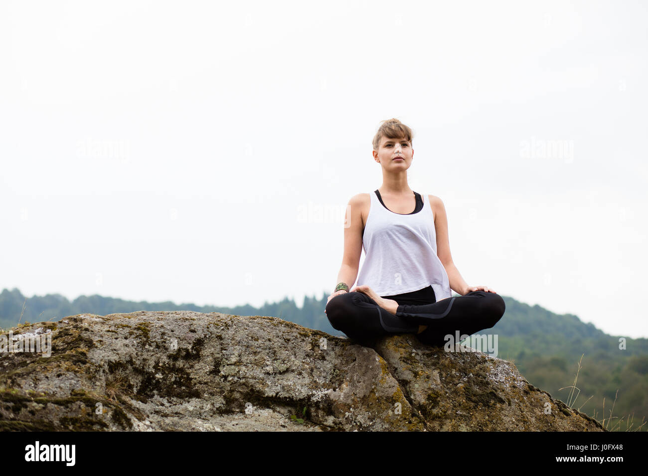 Young Beautiful woman doing yoga sur le sommet des montagnes Banque D'Images