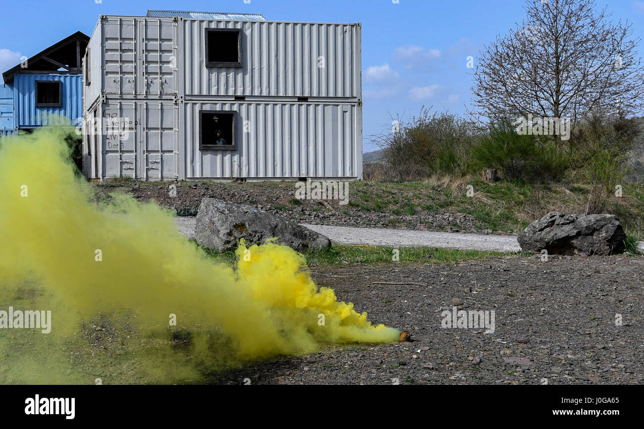 La fumée s'élève jaune hors de grenade de fumée au cours de l'exploitation urbaine partie de la 435e Escadron des Forces de sécurité au sol du Centre de préparation au combat au cours des opérations de sécurité de l'Armée américaine sur l'Allemagne, la garnison, Baumholder 4 Avril, 2017. Les étudiants avaient pour mission de parler à un chef de village et d'obtenir des renseignements de lui lorsqu'ils ont été attaqués et ont dû neutraliser la menace et le faire revenir à leur base. Aviateurs affectés à la 86e, SFS SFS SFS 422nd, 100e, et 569e Escadron de la police des forces américaines ont participé au cours. (U.S. Photo de l'Armée de l'air par la Haute Airman Tryphena Mayhugh) Banque D'Images