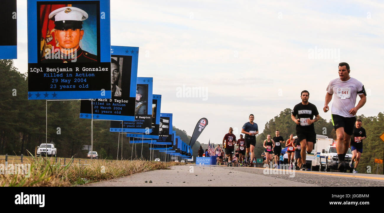 Tous les coureurs du Marathon américain se déplacer après un article de la concurrence qui est consacré à Mars, 26 membres de services, 2017 à Fayetteville, N.C. Le mémorial a été mis en place par des bénévoles avec l'organisation, l'usure bleu : exécuter pour se souvenir, qui appuie l'événement par une partie de la doublure de la race avec photos de militaires et holding flags en l'honneur de la nation du héros passés et présents. (U.S. Photo de l'armée par la FPC. Hubert D. Delany III/22e Détachement des affaires publiques mobiles) Banque D'Images