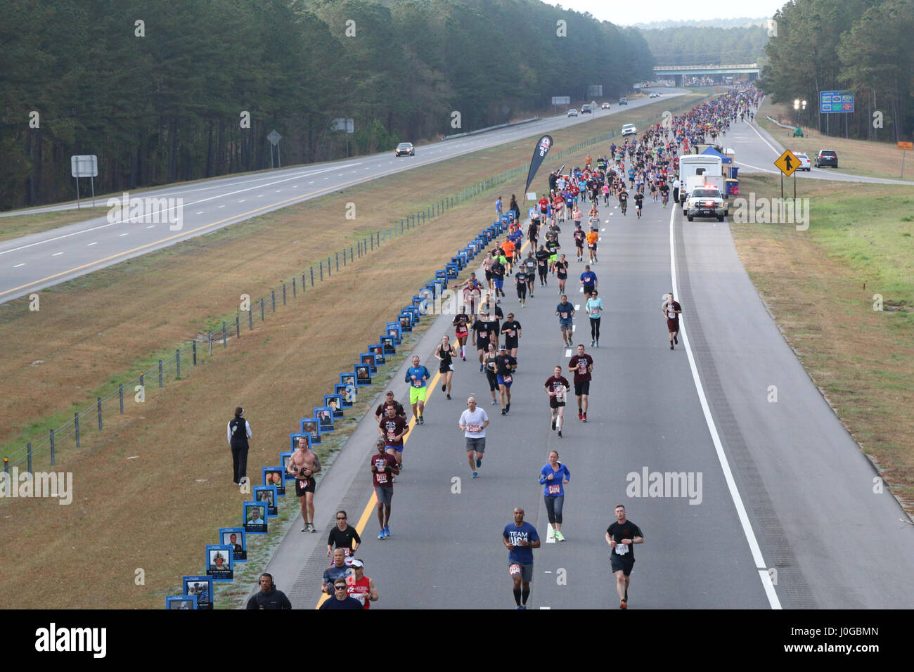 Tous les coureurs du Marathon américain se déplacer après un article de la concurrence qui est consacré à Mars, 26 membres de services, 2017 à Fayetteville, N.C. Le mémorial a été mis en place par des bénévoles avec l'organisation, l'usure bleu : exécuter pour se souvenir, qui appuie l'événement par une partie de la doublure de la race avec photos de militaires et holding flags en l'honneur de la nation du héros passés et présents. (U.S. Photo de l'armée par la FPC. Hubert D. Delany III/22e Détachement des affaires publiques mobiles) Banque D'Images