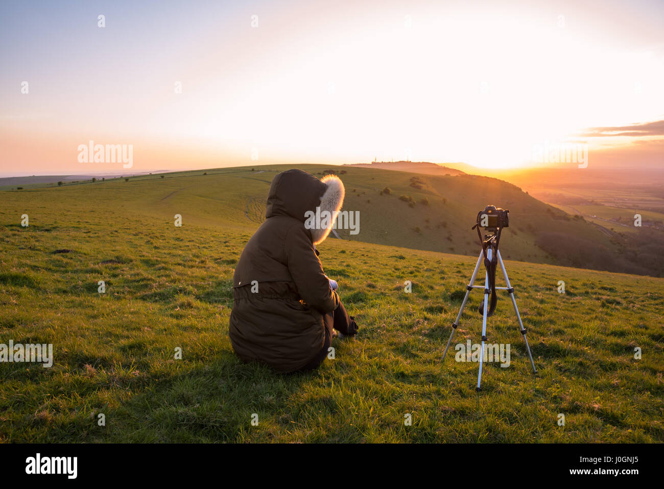 Photographe de prendre des photos à partir d'une colline, au coucher du soleil. Appareil photo sur un trépied Banque D'Images