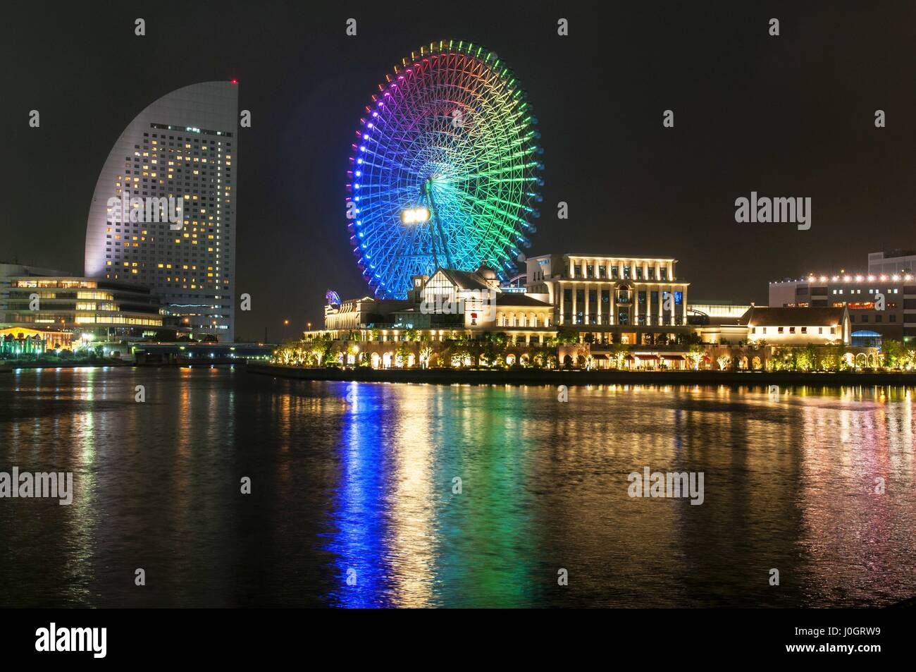 Scène de nuit illuminée de la Shinko salon dans le quartier de Minato Mirai 21 de Yokohama, Japon y compris le Cosmo World amusement park Banque D'Images