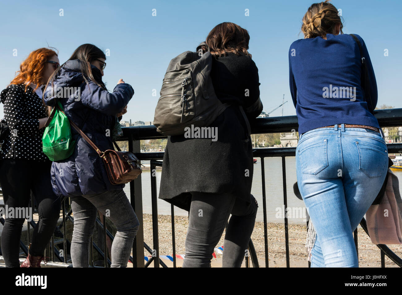 Les gens qui regardent la Tamise par débit au London's South Bank. Banque D'Images