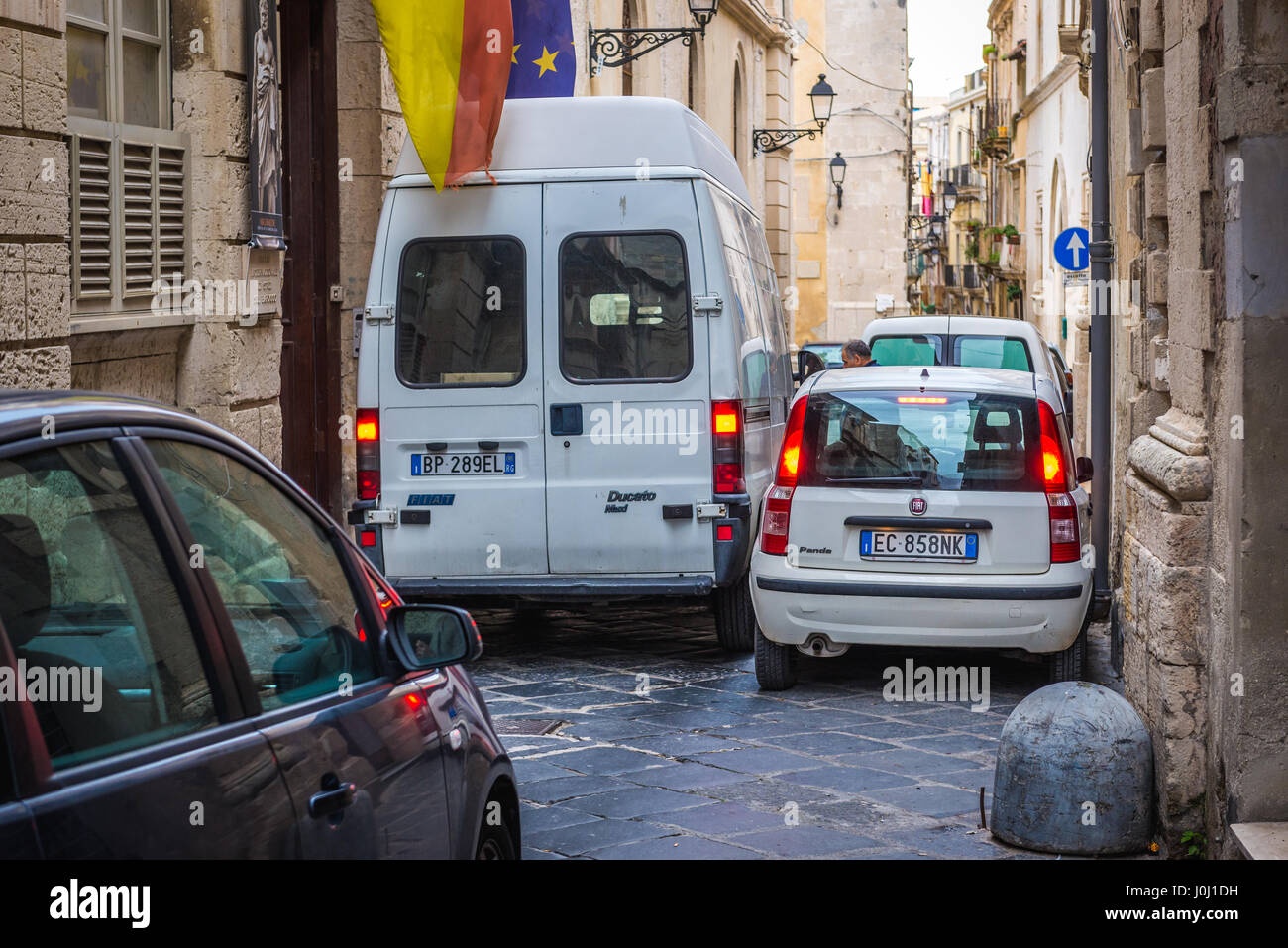 Voitures sur rue étroite sur l'île d'Ortygie, partie historique de la ville de Syracuse, l'angle sud-est de l'île de la Sicile, Italie Banque D'Images