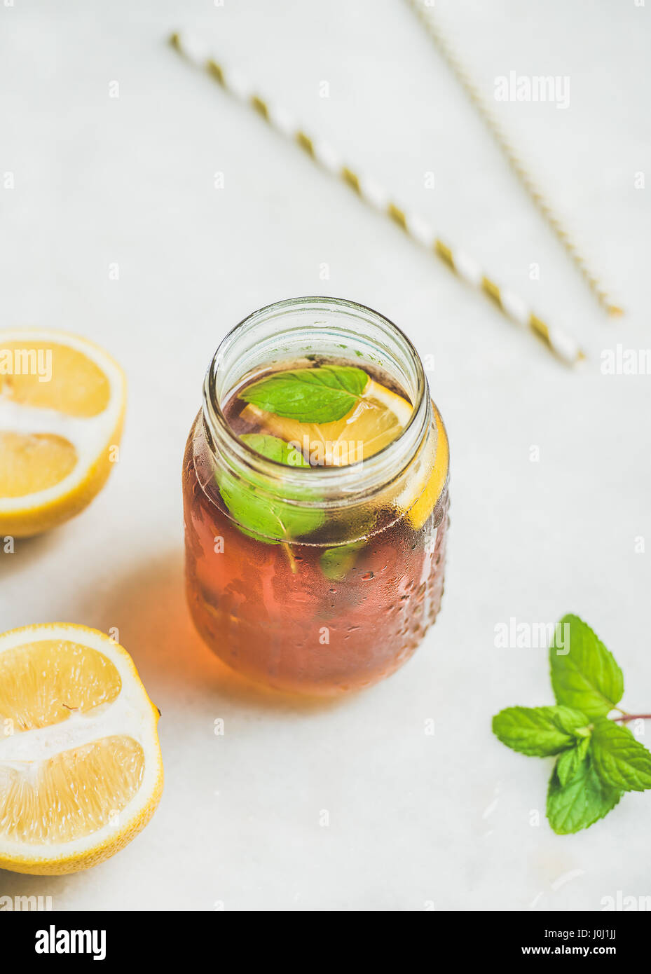 Rhume d'été thé glacé avec les tranches de citron et d'herbes fraîches Banque D'Images