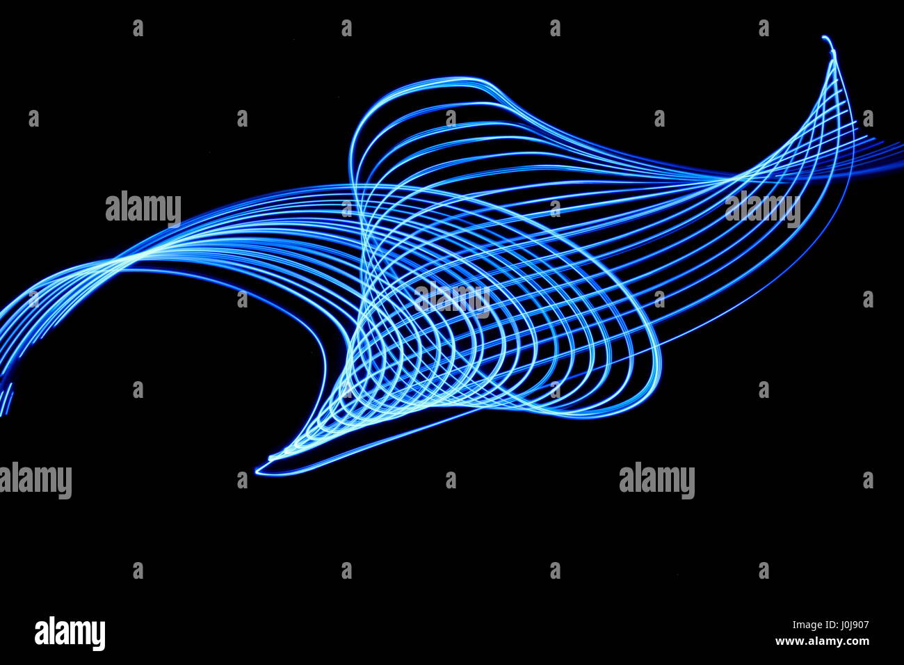 Lumière bleue peinture photographie - lignes parallèles dans un motif tourbillonnant sur fond noir. Une longue exposition photo de couleur bleu abstrait. Banque D'Images