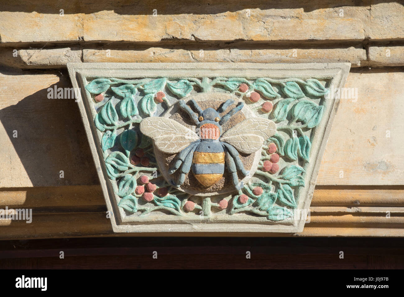 Bumble bee peint sculpture sur pierre de Cotswold sur le linteau au dessus de l'entrée hall Woolstaplers, Chipping Campden, Cotswolds, Gloucestershire, Angleterre Banque D'Images