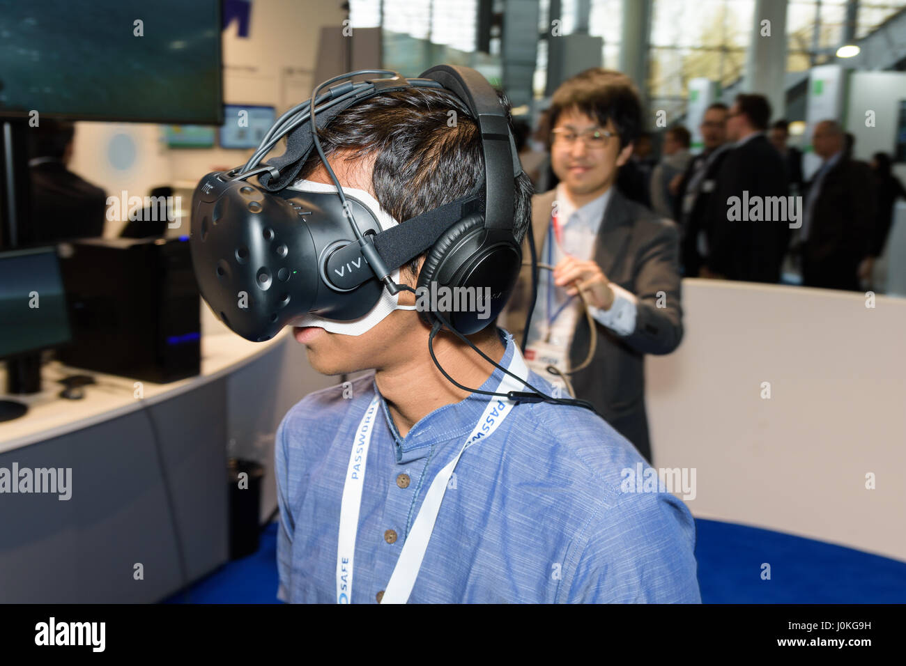 Hanovre, Allemagne - le 22 mars 2017 : Jeune homme porte l'HTC vive casque vr au CeBIT 2017. CeBIT est le plus grand salon professionnel pour elle. Banque D'Images