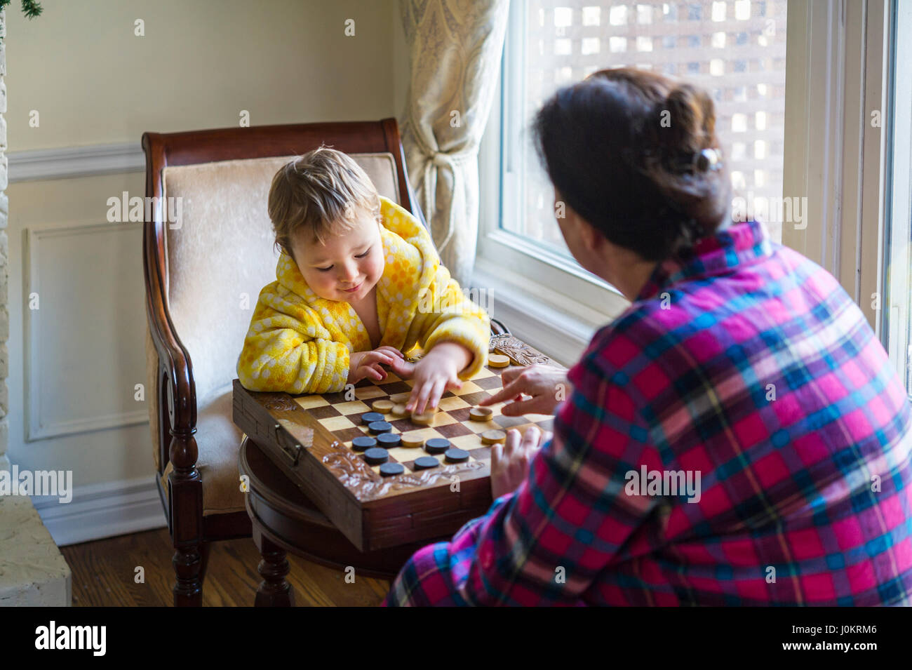 Garçon de 2 ans jouer avec checkers Banque D'Images