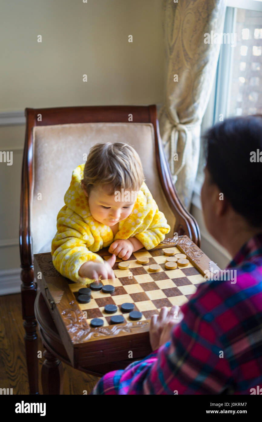 Garçon de 2 ans jouer avec checkers Banque D'Images