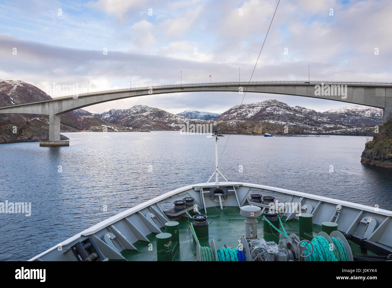 Navire Hurtigruten, Mme Richard avec, fait son chemin à travers l'étroit détroit de Stokksund, la Norvège, sous l'autoroute 723 Pont à Stokknes. Banque D'Images