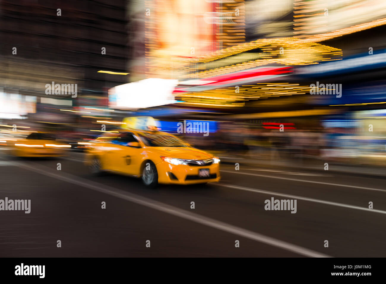 Yellow Taxi Cab Driving Through Times Square la nuit, New York, USA Banque D'Images