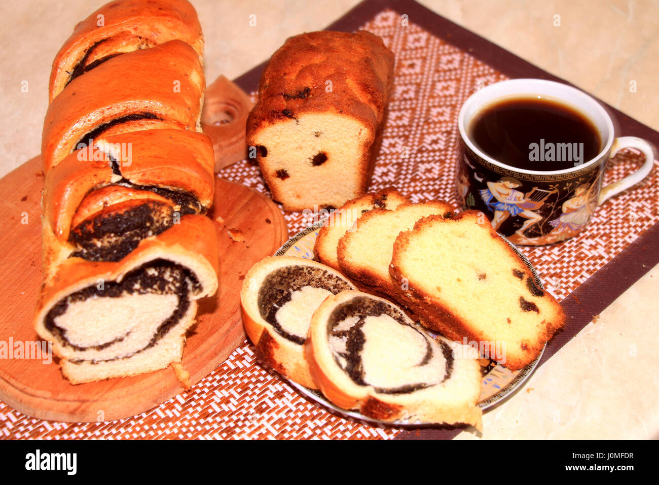 Les produits de boulangerie. Rouleau avec les graines de pavot, le raisin-gâteau avec du café - un petit-déjeuner copieux le matin. Banque D'Images