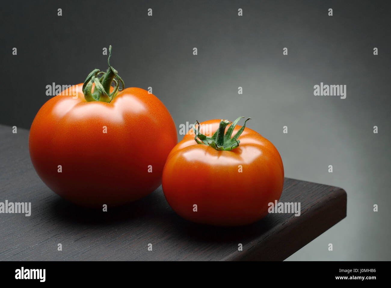Nature morte avec deux tomates rouges sur la table. Banque D'Images