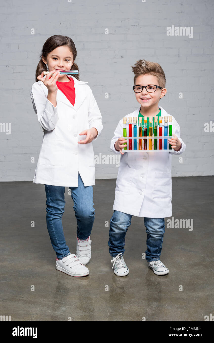 Cute little kids en sarrau holding test tube avec des échantillons chimiques colorés Banque D'Images