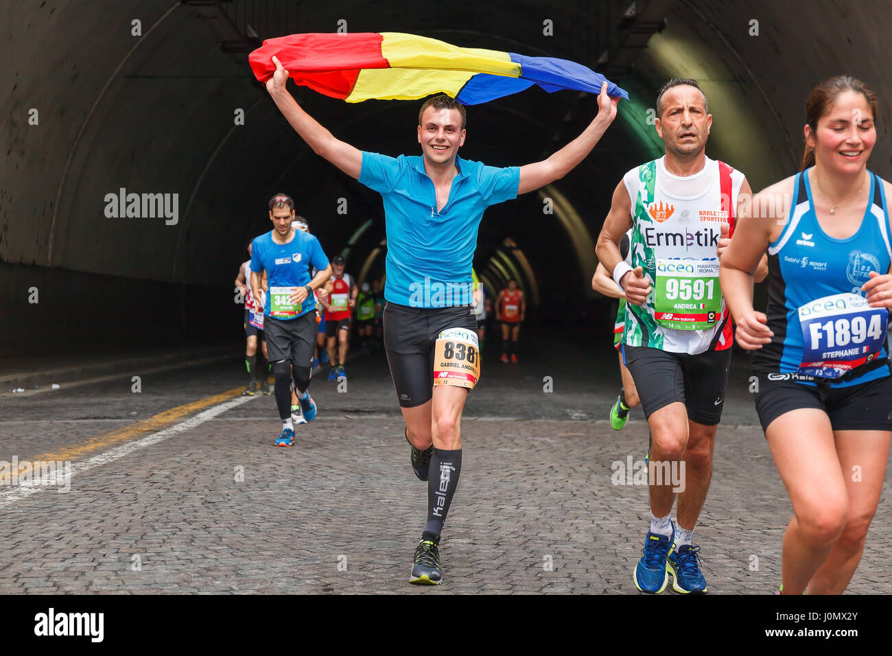 Rome, Italie - 2 Avril, 2017 : Romanian boy waving flag. Les athlètes de la 23e Marathon de Rome pour le passage du tunnel Umberto I, à quelques kilomètres de f Banque D'Images