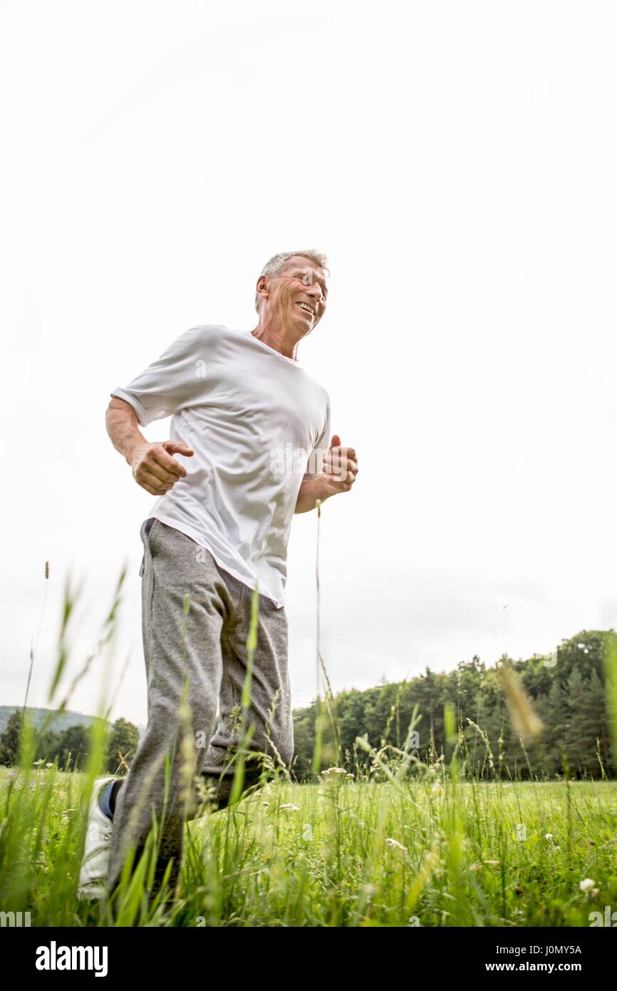Senior man jogging dans l'herbe. Banque D'Images