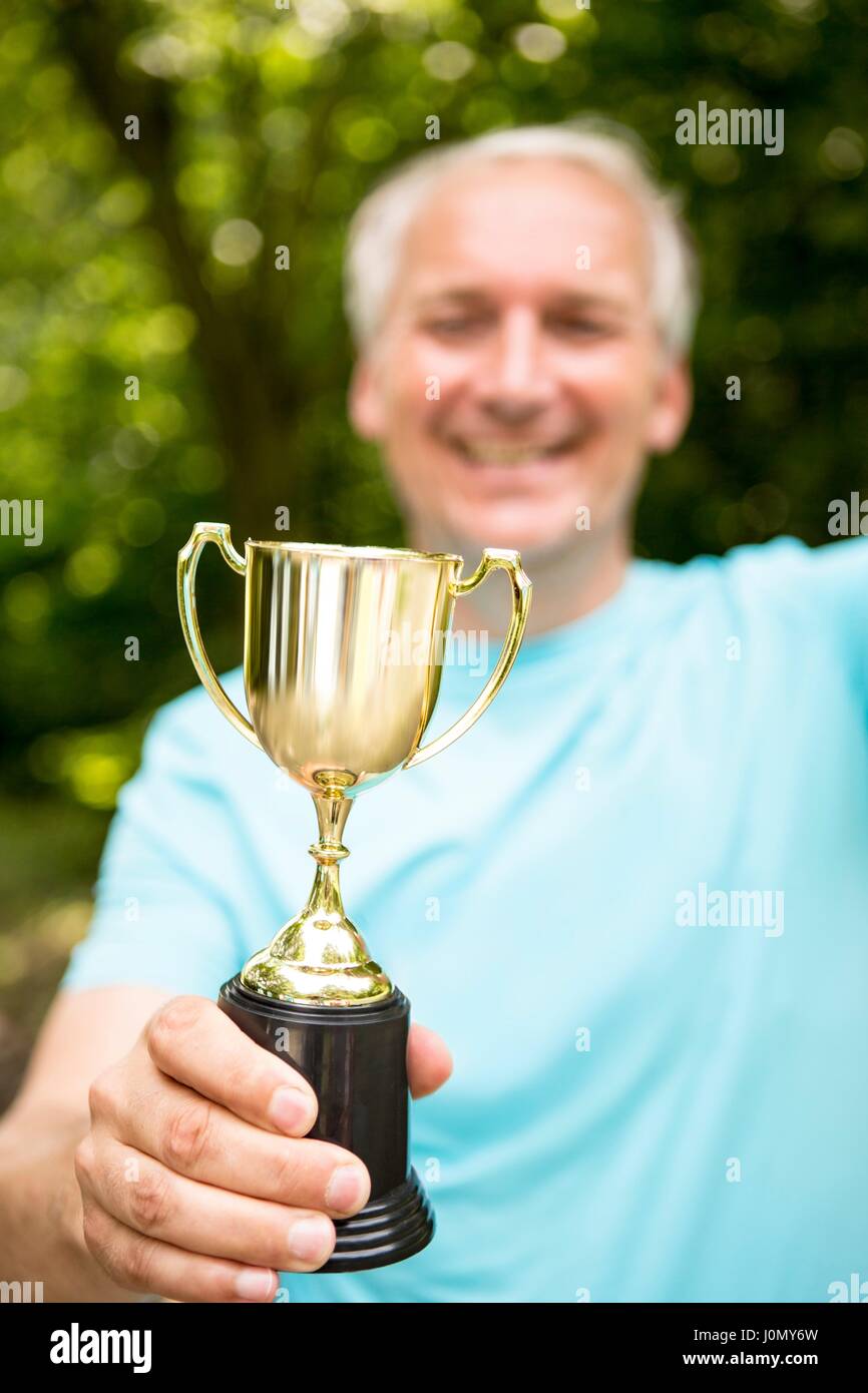 Homme mature tient un trophée. Banque D'Images