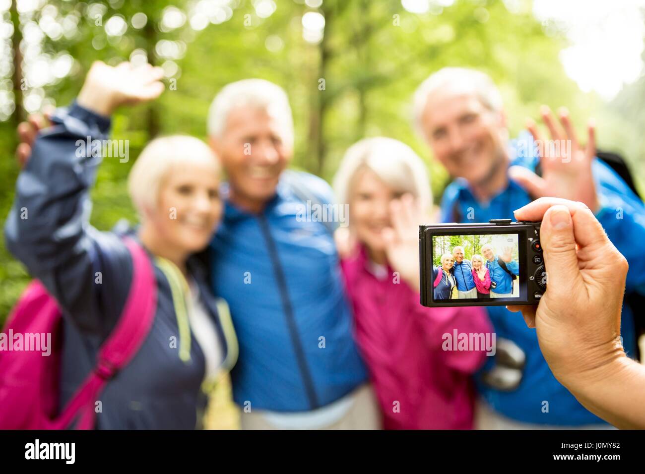 Personne prenant photo de quatre randonneurs avec appareil photo numérique. Banque D'Images