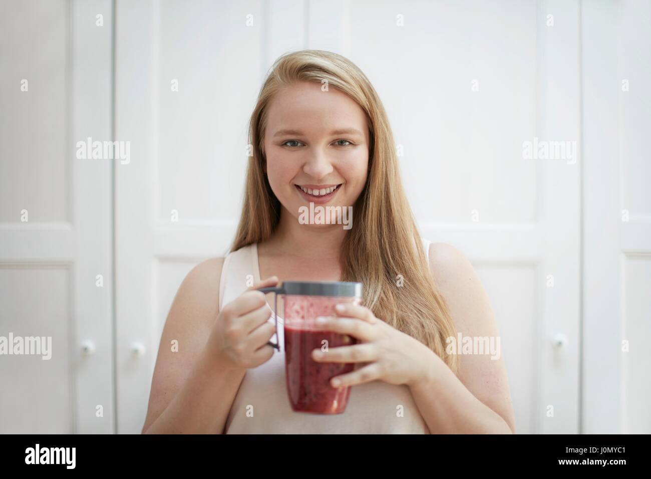 Jeune femme à boire smoothie fait maison. Banque D'Images