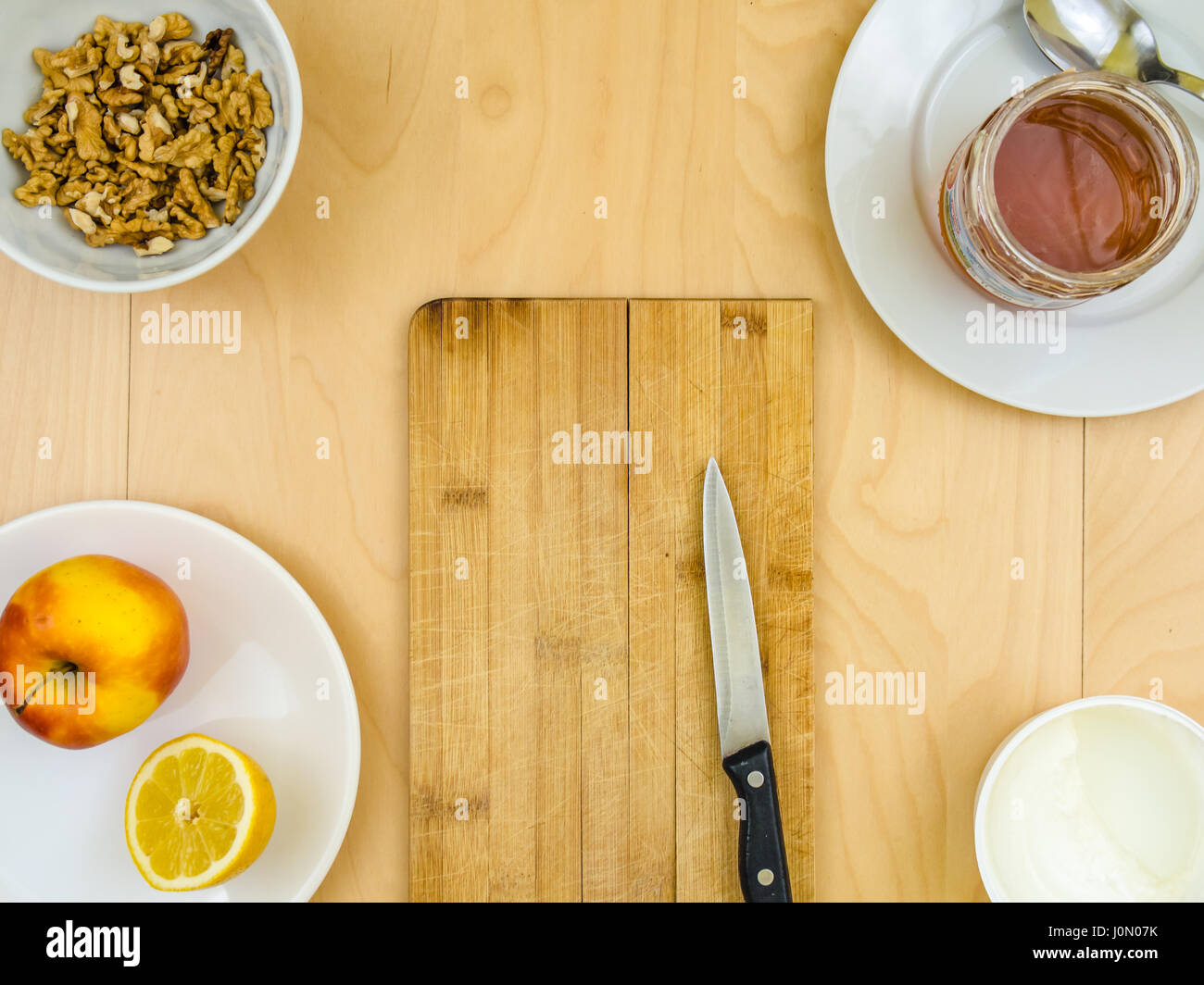 Quatre ingrédients pour une alimentation saine et nutritive snack ou smoothie, autour d'office et couteau, citron pomme fruits, fromage cottage, fruits secs décortiqués walnu , miel Banque D'Images