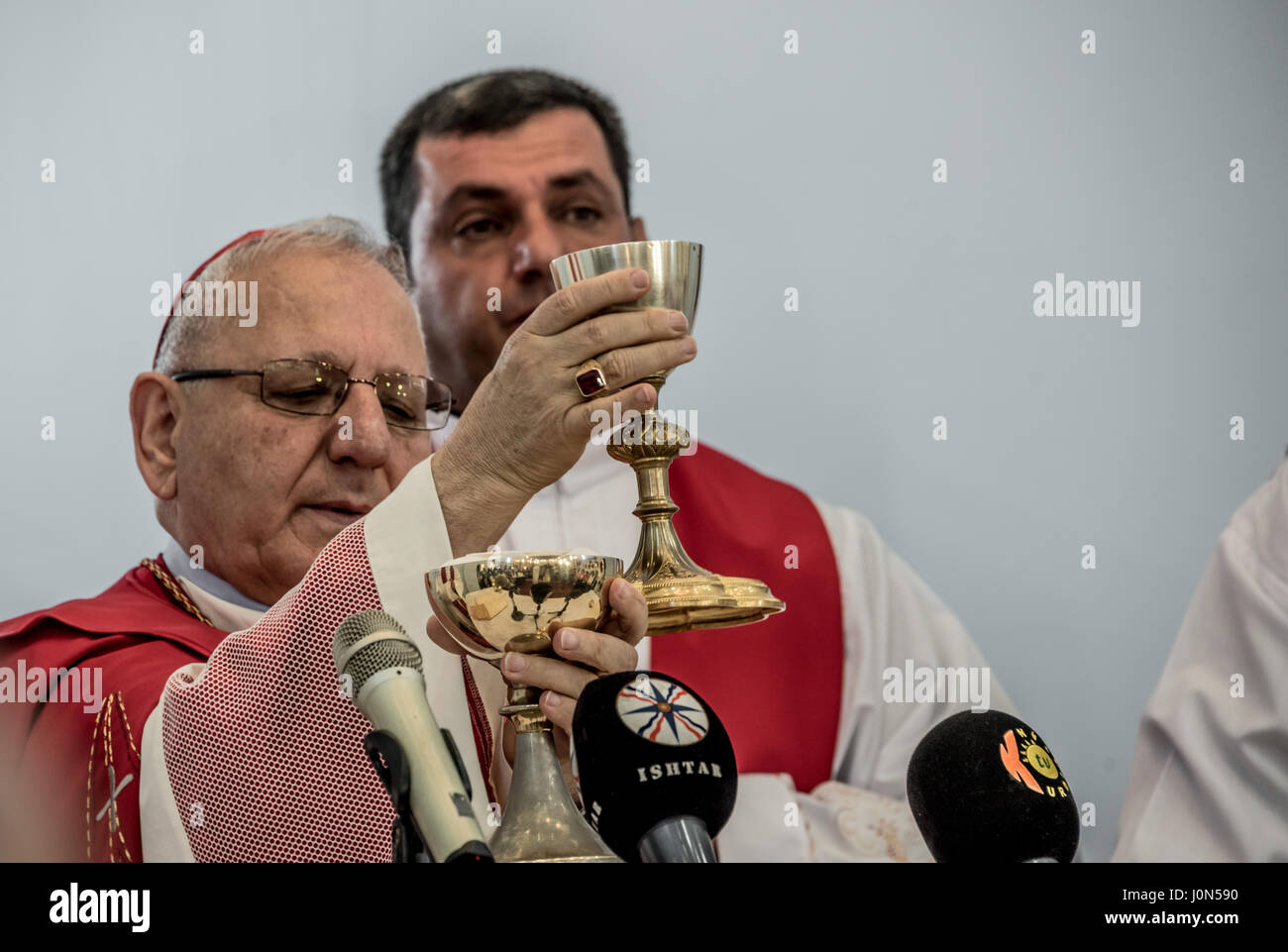 En Irak Pâques Jeudi Saint : lavage des pieds avec Mar Raphaël Louis Sako - Relever la Communion calices Banque D'Images