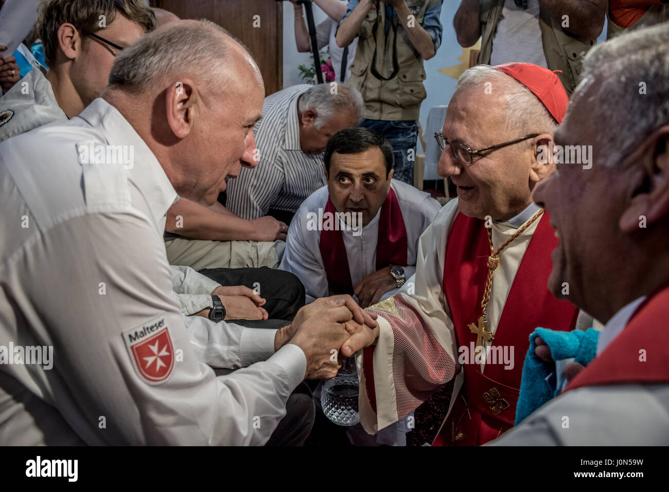 En Irak Pâques Jeudi Saint : lavage des pieds avec Mar Raphaël Louis Sako - serrant la main d'un membre de l'organisation de défense des droits de Cottbus, Allemagne. Banque D'Images