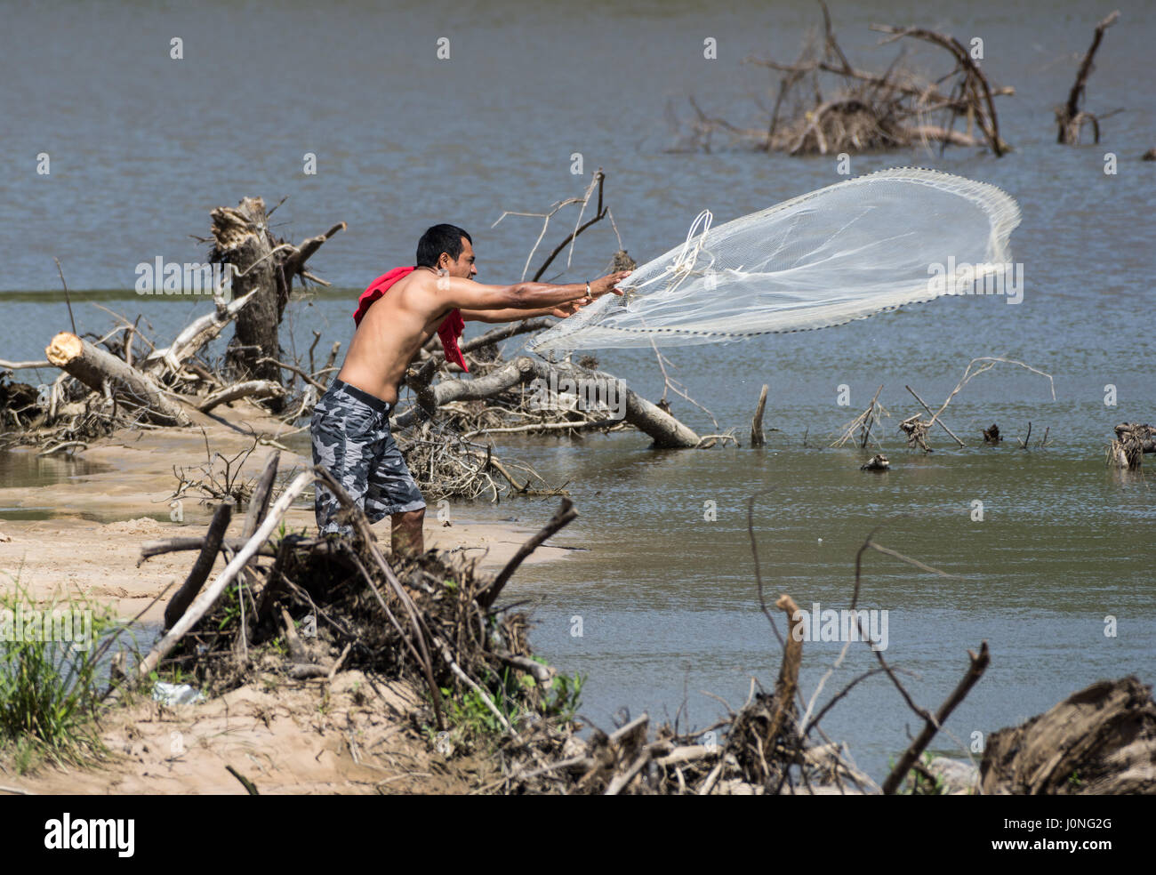 Un homme pêche par une rivière avec un filet. Texas, États-Unis Banque D'Images