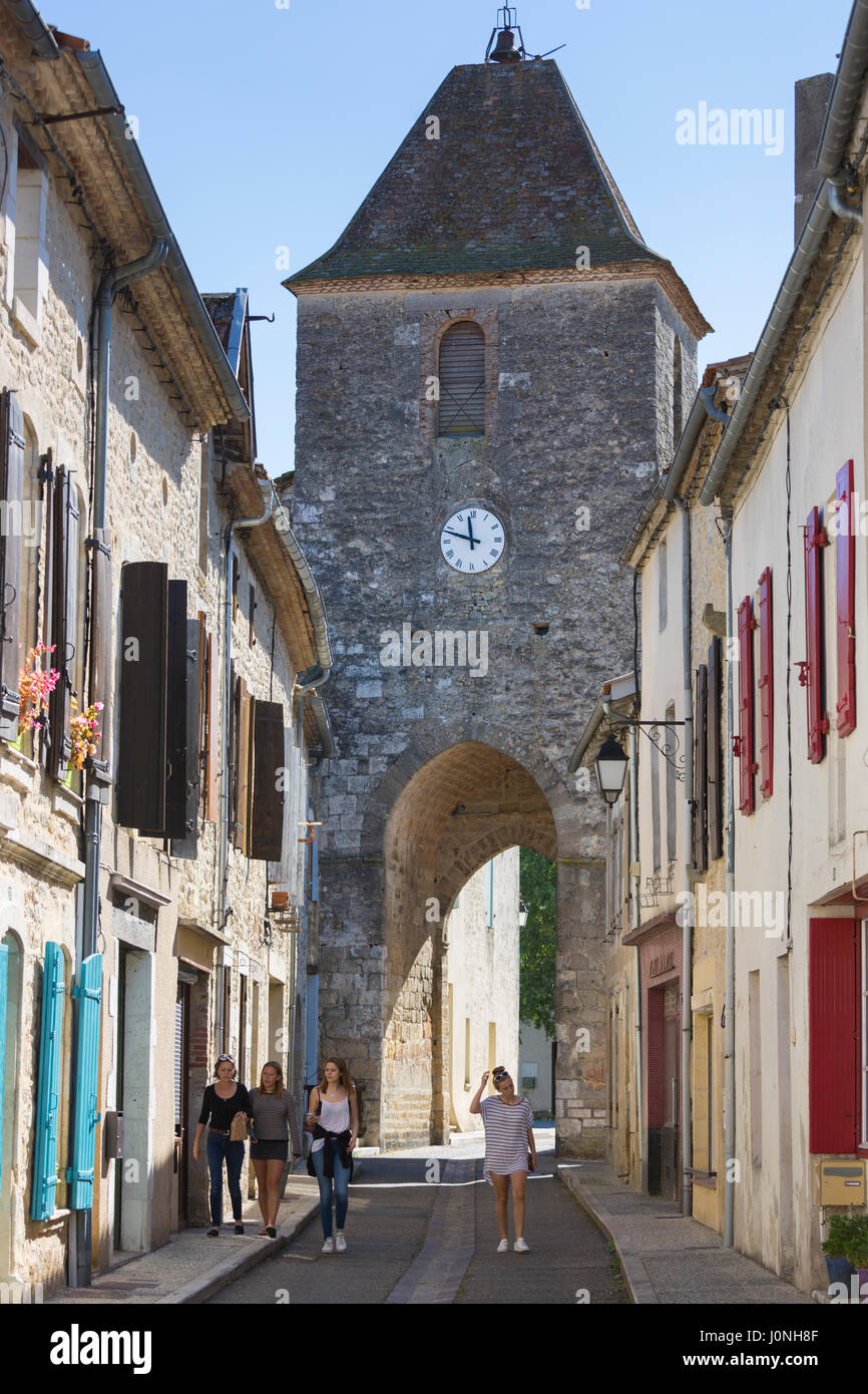 Touristes par la tour médiévale de l'horloge du XIIIe siècle dans l'ancienne bastide fortifiée de Duras en Aquitaine, France Banque D'Images