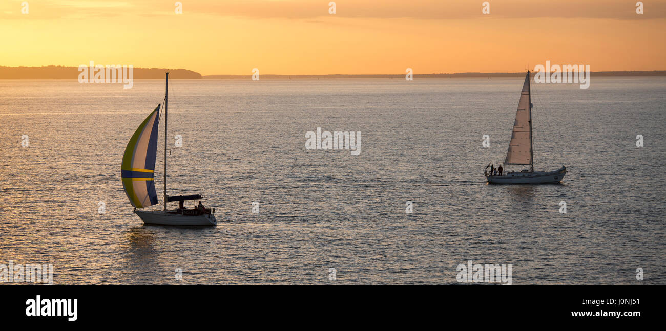 Bateaux à voile en mer au coucher du soleil par la rivière Solent, UK Banque D'Images