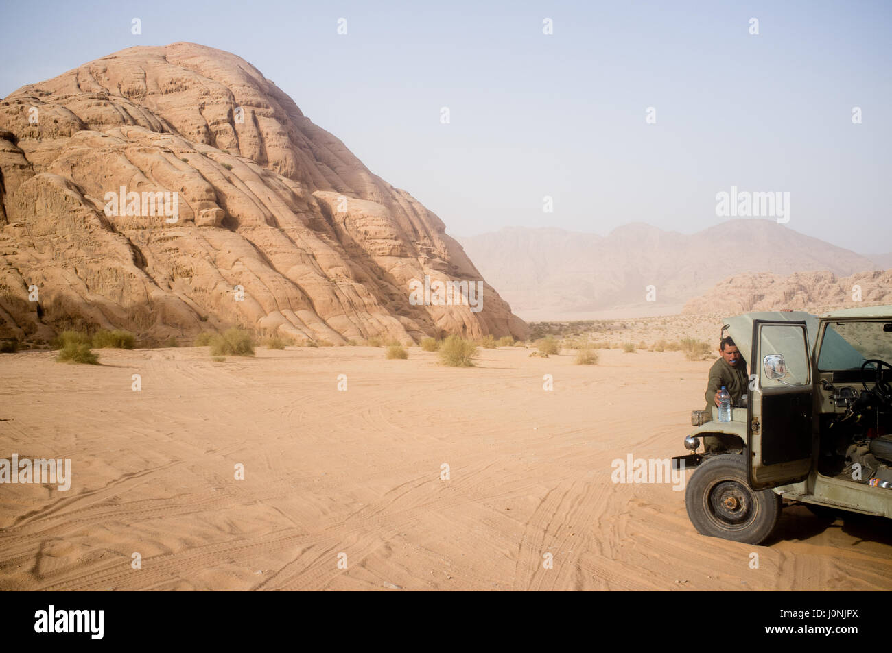 Pilote de mousseline la réparation d'une voiture endommagée au milieu de rien. Le désert de Wadi Rum. La Jordanie. Banque D'Images
