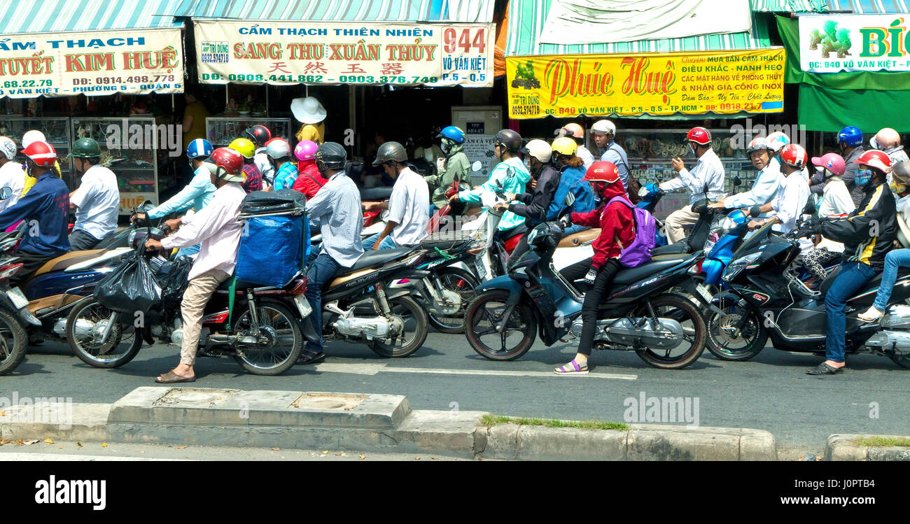 Les motocyclistes en attente de feux de circulation pour changer à Ho Chi Minh City Banque D'Images