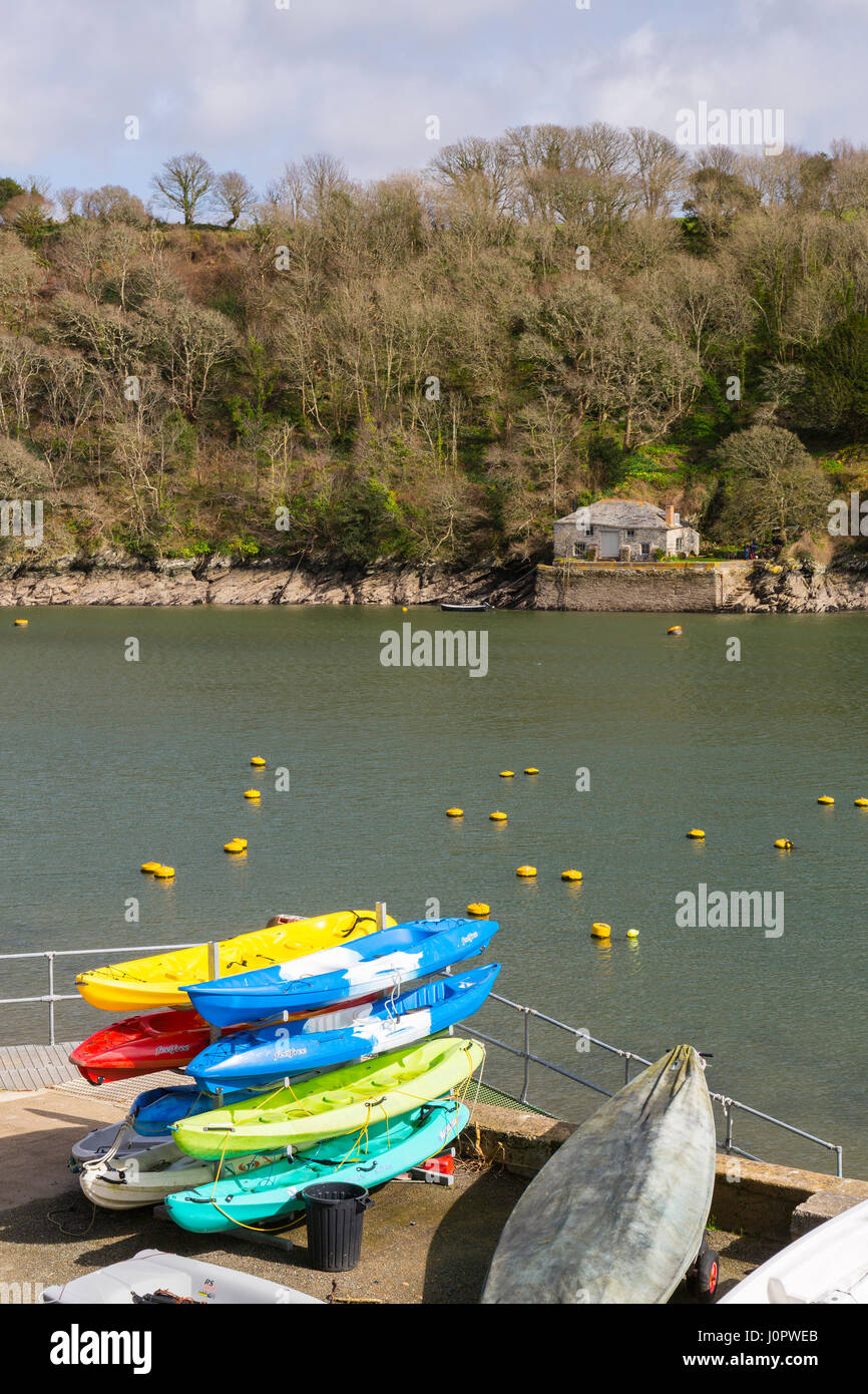 Kayaks de mer sur une rive de la rivière Fowey en face d'un Cornish cottage traditionnel et historique, Fowey, Angleterre Banque D'Images