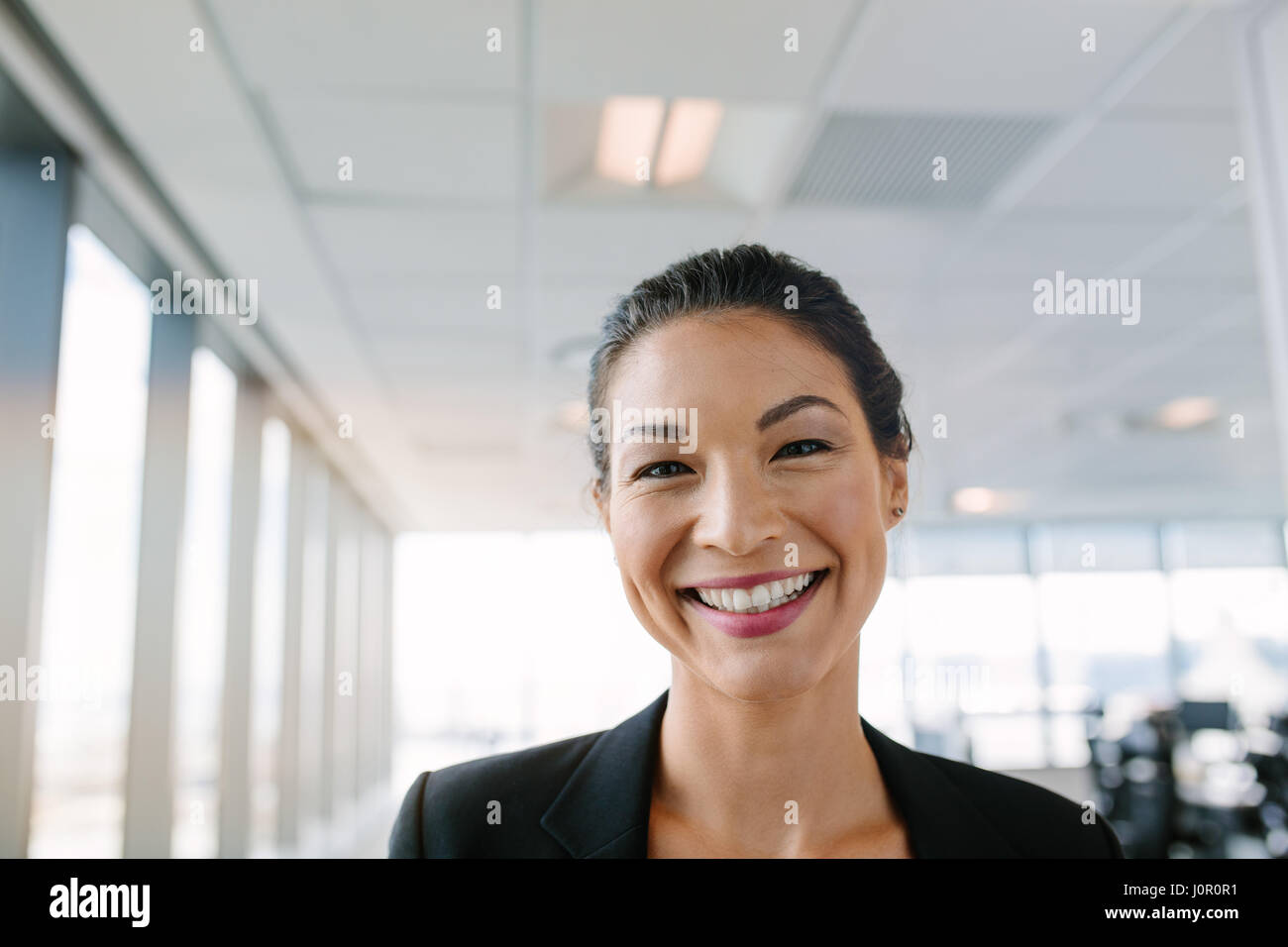 Portrait de belle mature businesswoman standing in office. Femme entrepreneur asiatique looking at camera avec un grand sourire sur le visage. Banque D'Images