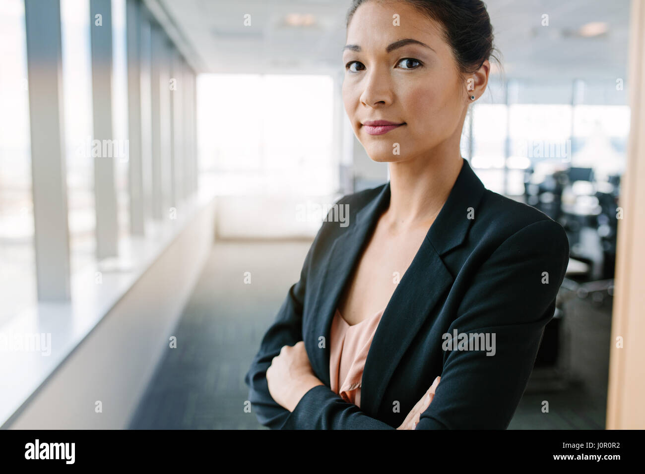 Portrait of mature businesswoman standing in office avec les bras croisés. Femme entrepreneur asiatique en litige looking at camera en toute confiance. Banque D'Images