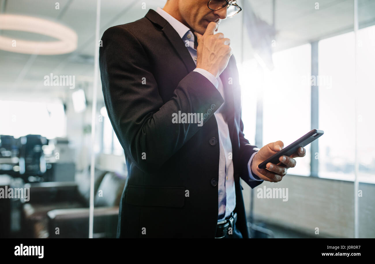 Cropped shot of woman in office et de penser. Male executive holding smart phone. Banque D'Images